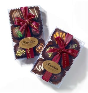 Six delicious hand decorated chocolates in a clear acrylic box by Davies Chocolates