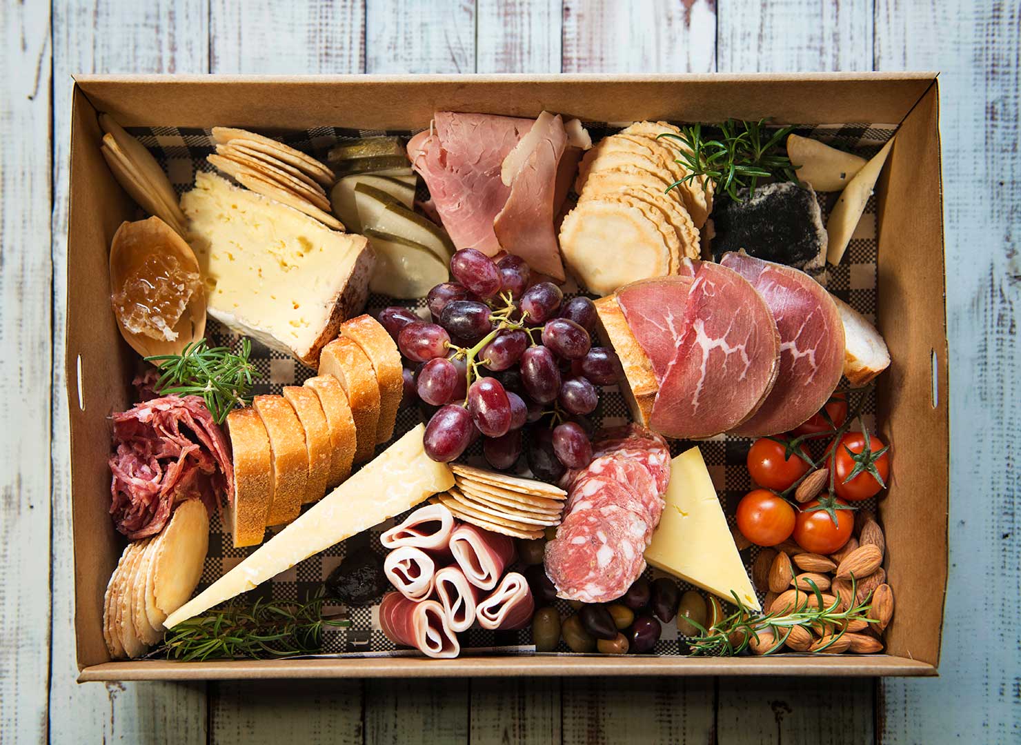 A mouth watering premium gourmet platter box of artisan farmhouse cheeses, cured meats sliced in house, fresh seasonal fruits and accompanied with Australian olives, pickles, semi dried tomatoes & much more. Complete with sourdough baguette or bread & crackers. One of our best sellers and only contains Australian produce. 